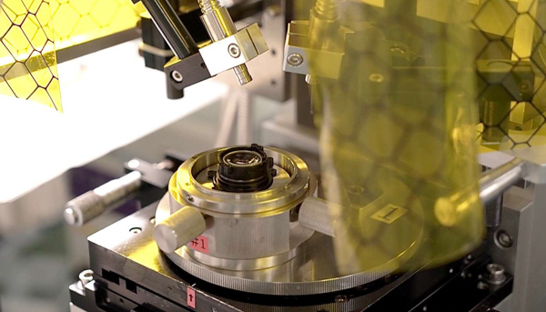 Một thành phần trong ống kính XF 35mm f/2 đang trong quá trình xử lý dưới tia UV.