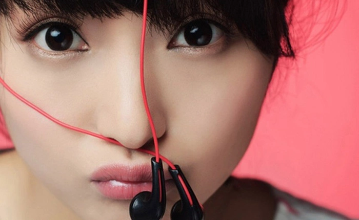 Thiếu nữ có vẻ đẹp thiên thần làm dáng với tai nghe