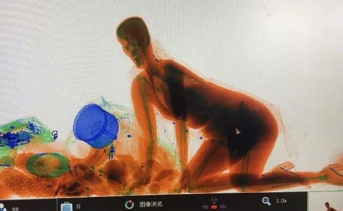 Sợ bị lấy mất túi xách, người phụ nữ Trung Quốc trèo luôn vào máy quét hành lý