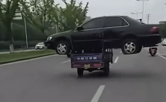 Thanh niên bị phạt 1300 tệ vì chở nguyên một chiếc ô tô bằng xe ba gác